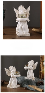 Detail of vintage resin angel candle holder with wings and glass cup for tea lights