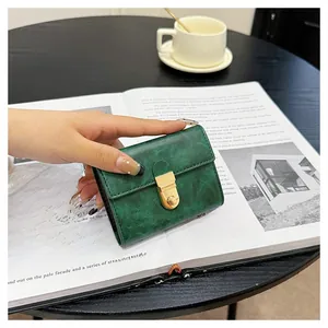 Close-up of a vintage dark green marble texture card holder with a gold metal clasp