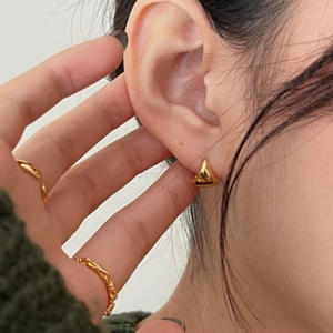 Close-up of minimalist gold-plated triangular stud earring on a model's ear