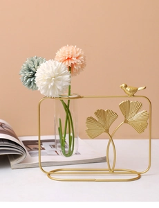 Detail of golden ginkgo leaf iron art vase with glass tube and artificial flowers