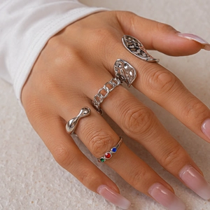 Detail of a 4-piece silver ring set featuring lava texture and colorful gemstones