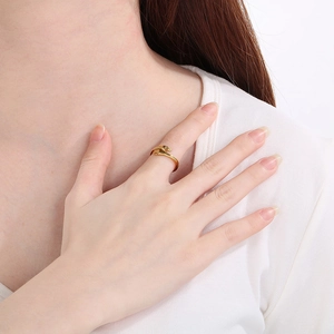 Detail of adjustable gold embrace ring showing the hands hugging design on a model's finger