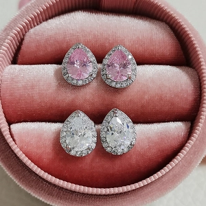 Detail of pear-shaped halo stud earrings in pink and clear stones on velvet