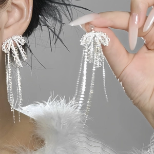 Detailaufnahme eleganter silberner Schleifen-Ohrringe mit glitzernden Strasssteinen