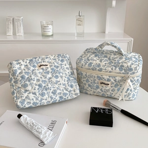 Two-piece floral quilted cotton makeup bag set with top handle and blue herbal pattern