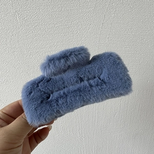 Close-up of fuzzy rectangular hair claw clip in elegant misty blue plush fabric