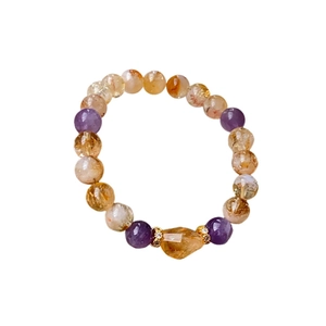 Elegant purple and yellow crystal beaded bracelet with gold accents on a white background