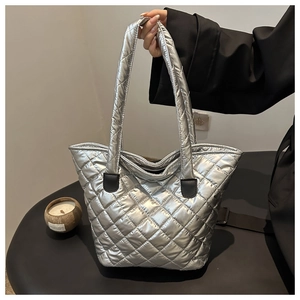 Détail d'un sac cabas argenté métallisé matelassé avec des anses contrastées