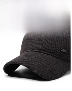 Close-up of textured baseball cap with curved brim and metal brand plaque detail