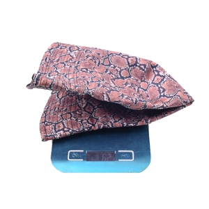 Detailed view of snake skin pattern bucket hat on digital scale weighing 62 grams