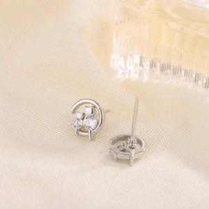 Elegant cat and moon stud earrings with sparkling cubic zirconia on linen background