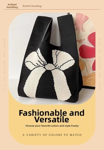 Detail of knitted tote bag in black with a large white contrast bow pattern on textured fabric