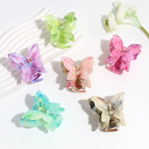 Detail of six colorful gradient butterfly hair claws in marble resin texture on white decor