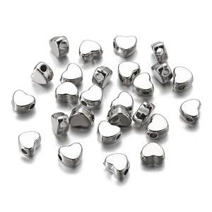 Nahaufnahme silberner herzförmiger 7mm Zwischenperlen mit Löchern für DIY-Schmuck