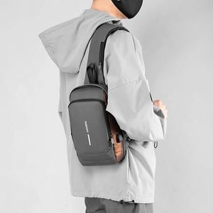 Close-up of waterproof grey chest bag for men showing side USB charging port detail