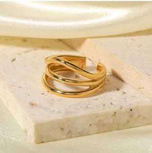 Macro detail of 18K gold-plated multilayer open ring on elegant marble stone and silk
