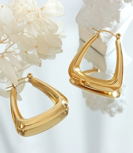 Macro shot of gold-plated U-shaped geometric earrings with a high-polished finish