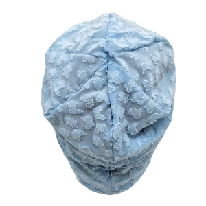 Close-up of light blue slouchy beanie featuring a 3D embossed butterfly pattern fabric