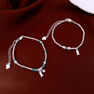 Dettaglio dei bracciali in argento con pendente a pesce, perline blu e perle d'acqua dolce