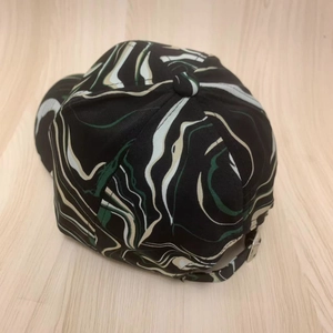 Rear view of striped baseball cap with abstract marble print and silver metal buckle