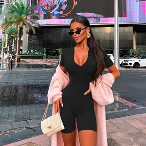 Close-up of a black V-neck short sleeve bodysuit paired with a pink plush faux fur jacket