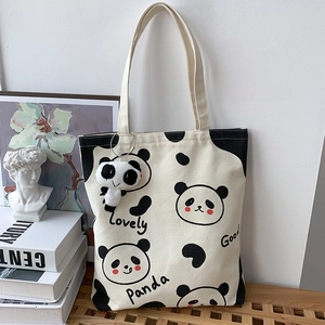 Detail der Panda-Stofftasche mit süßen Drucken und einem Panda-Plüsch-Anhänger