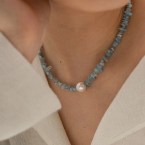 Titanium steel necklace with blue natural gravel and central white pearl on a model