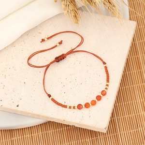 Handmade bohemian beaded bracelet with orange natural stones and woven cord