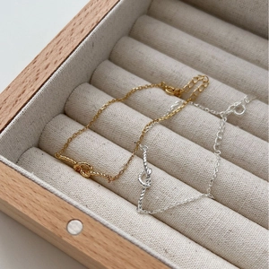 S925 sterling silver woven heart bracelets in gold and silver on a wooden jewelry tray