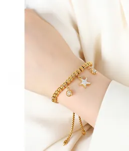 Macro detail of gold-plated stainless steel beaded bracelet with starfish and zircon charms