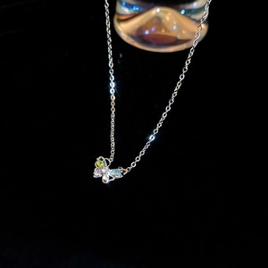 Macro shot of colorful zircon butterfly pendant with silver link chain on black background