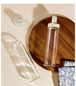 Leak-proof glass oil bottle with white spout lid on a rustic wooden board detail
