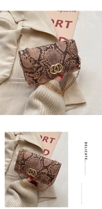 Detail of snake skin texture and golden metal ring buckle on a crossbody bag