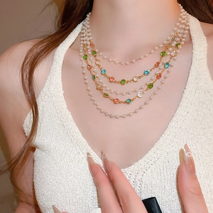 Close-up of multilayer pearl and colorful gemstone necklace on model neck