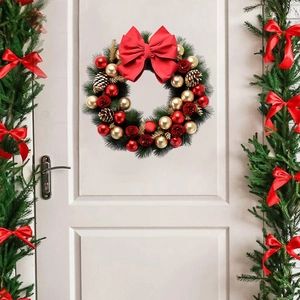 Christmas wreath with red bows and pine cones on white door for festive wall decoration