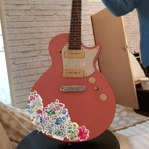 Guitare électrique rose avec divers autocollants de graffitis floraux colorés
