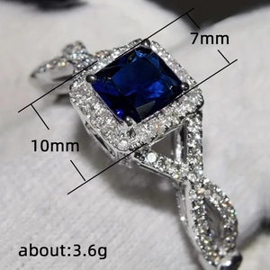 Bague géométrique croisée avec pierre précieuse bleue carrée et anneau tissé diamanté