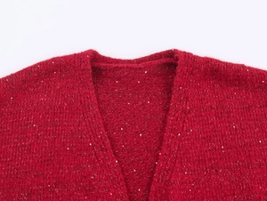 Détail du cardigan rouge avec paillettes argentées brillantes et texture du col en V