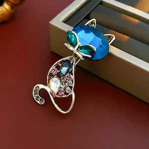 Elegant gold fox brooch with blue crystal head and colorful rhinestones on jewelry box