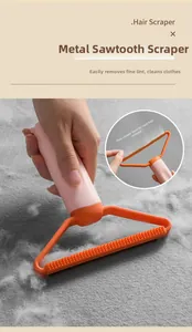 Macro view of portable lint remover with metal head cleaning hair from grey fabric
