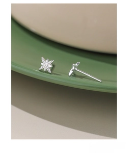 Macro shot of S999 sterling silver star stud earrings with visible S999 certification mark
