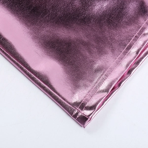 Dettaglio del tessuto rosa metallizzato con cuciture di precisione su una minigonna