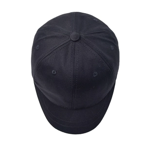 Macro detail of high-density black cotton twill and six-panel stitching on short brim cap
