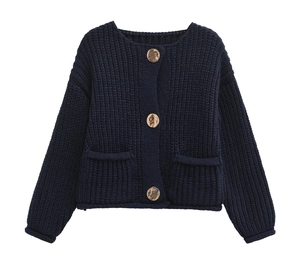 Detail of navy blue chunky knit cardigan featuring gold buttons and decorative pockets