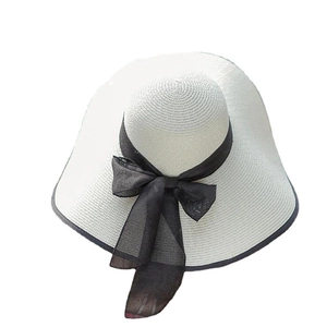 Cappello di paglia estivo a tesa larga con nastro di chiffon nero su sfondo bianco