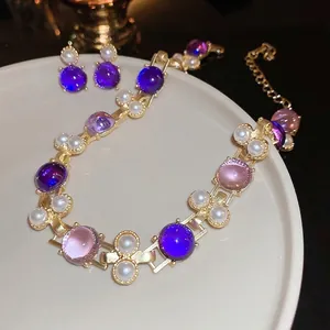 Parure de bijoux vintage avec pierres violettes et perles blanches dorées