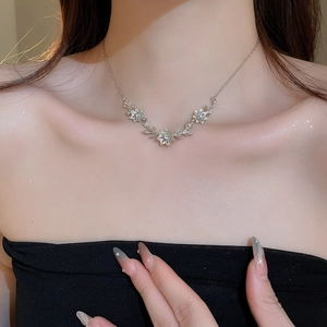 Detail of silver floral necklace with zircons on model's neck for elegant styling