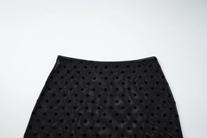 Détail de la jupe en résille à pois noirs montrant la taille et la texture du tissu