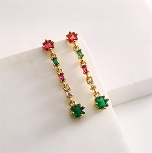 Boucles d'oreilles géométriques dorées avec zircons colorés sur pierre blanche
