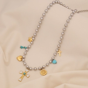 Detail of silver beaded necklace with gold heart star and turquoise cross pendants